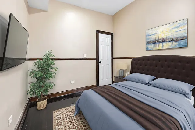 a bedroom with a large bed and a potted plant