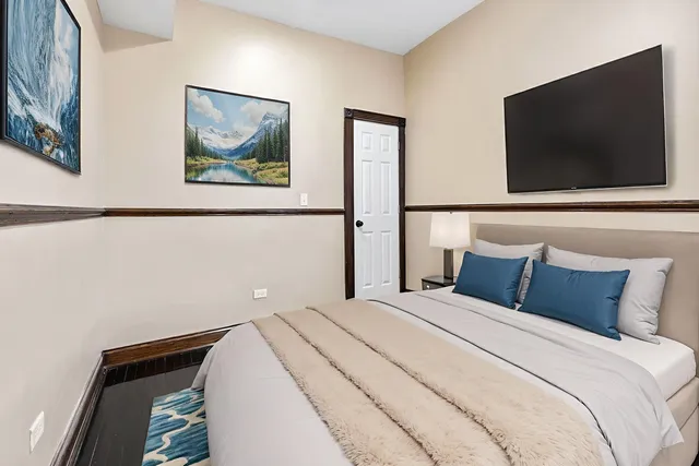 a bedroom with a bed and a flat screen tv