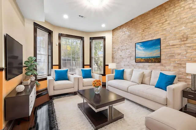 a living room with furniture a flat screen tv and a large window