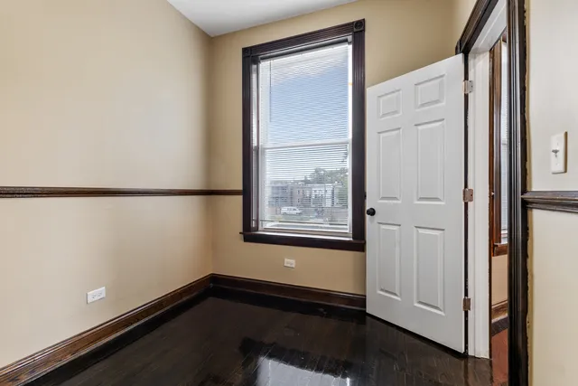 an empty room with a window and wooden floor