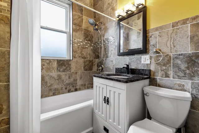 a bathroom with a granite countertop sink toilet and shower