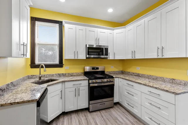 a kitchen with granite countertop a sink and cabinets