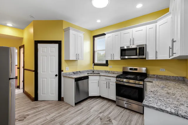 a kitchen with stainless steel appliances a stove a sink and a refrigerator