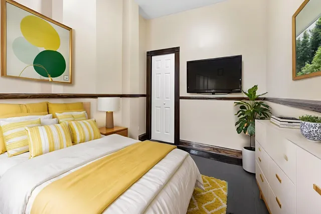 a bedroom with a bed and a potted plant