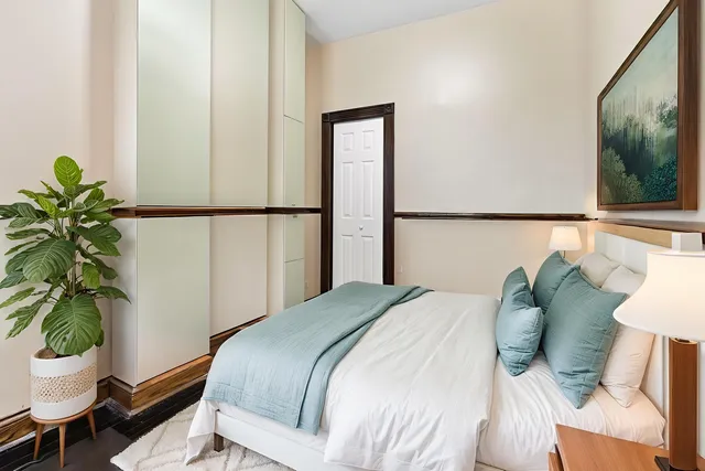 a bedroom with a bed potted plant with the mirror