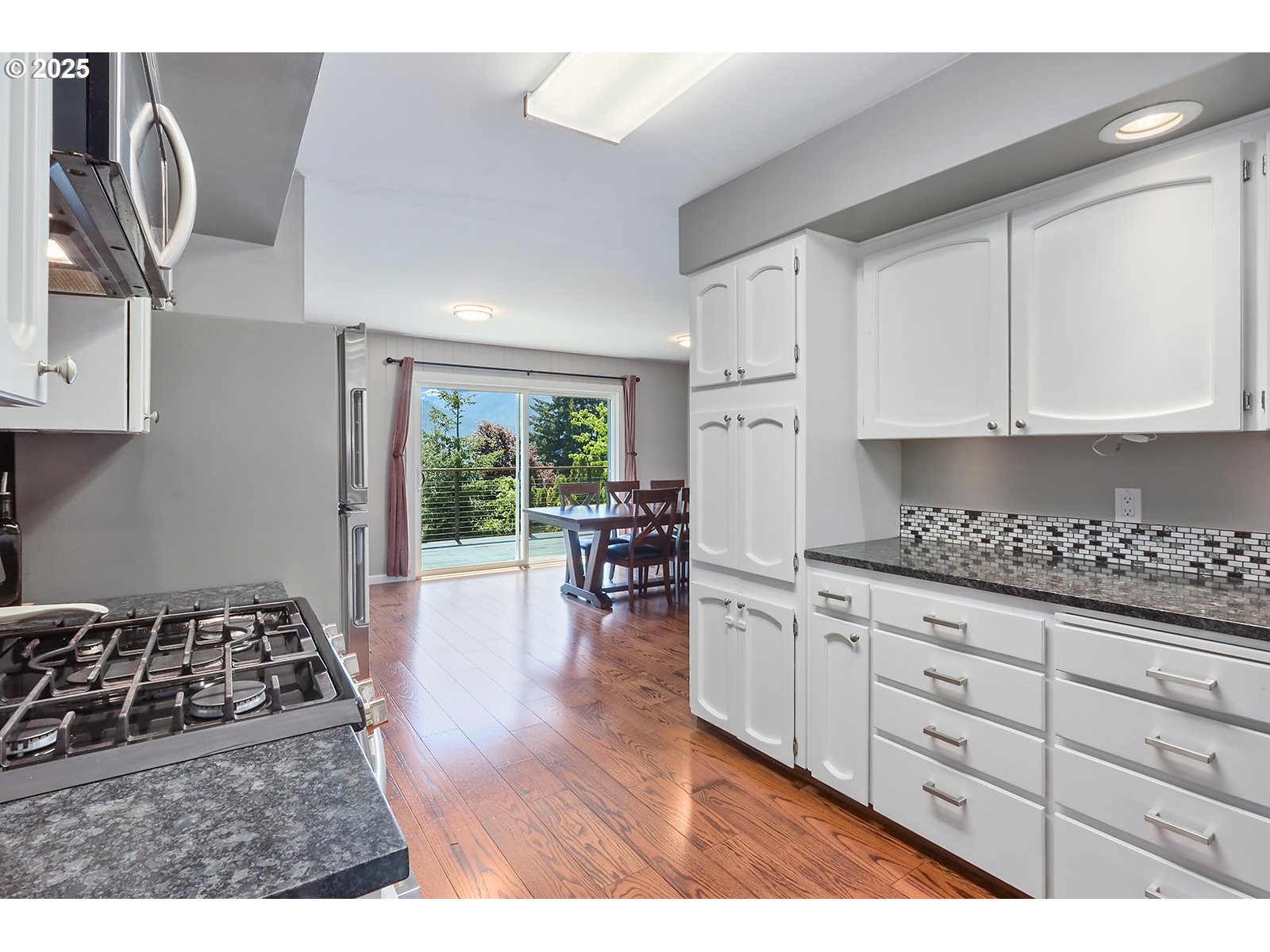 101 Allen Street Carson, WA 98610 - Photo 5 of 48 a kitchen with granite countertop a stove a sink a dining table and chairs