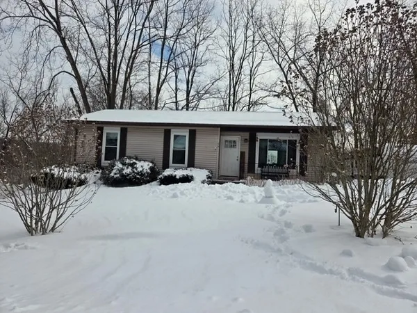 a view of a house with a yard covered in snow