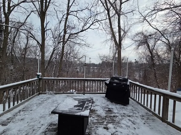 a view of a roof deck with couches and wooden fence