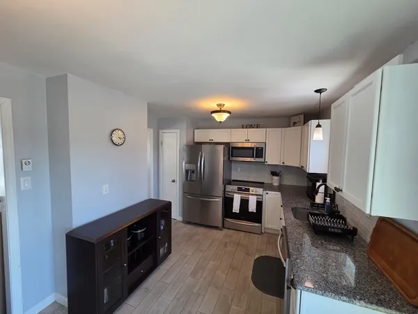 a kitchen with stainless steel appliances granite countertop a refrigerator and stove