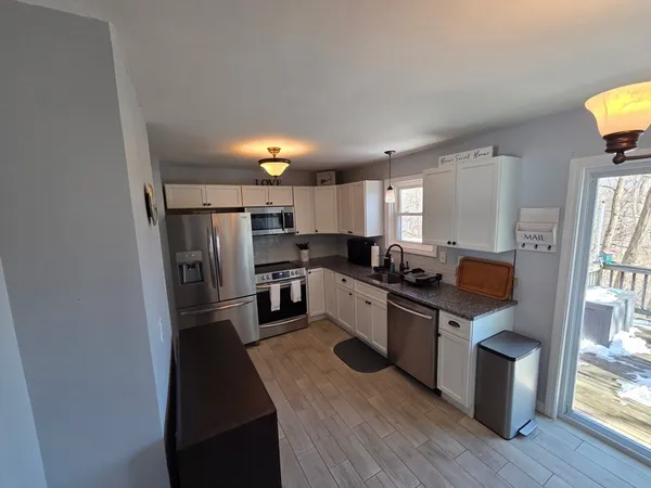 a kitchen with granite countertop a refrigerator stove and sink