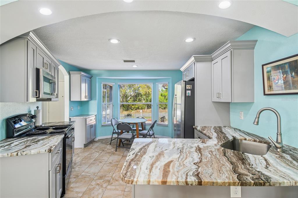 13170 Pirate Lane Spring Hill, FL 34609 - Photo 19 of 83 a bedroom with a bed couch and a large window