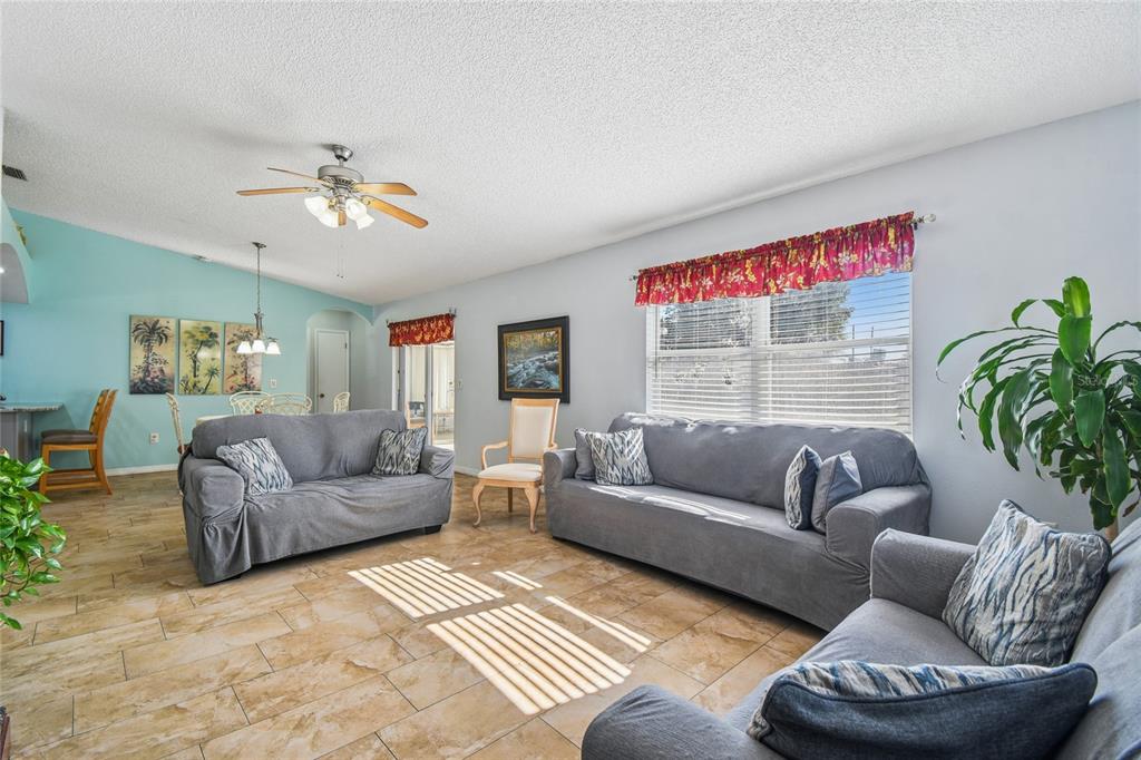 13170 Pirate Lane Spring Hill, FL 34609 - Photo 29 of 83 a living room with furniture and a chandelier