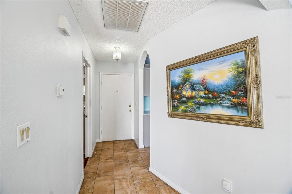 13170 Pirate Lane Spring Hill, FL 34609 - Photo 32 of 83 a view of a hallway with a painting on the wall