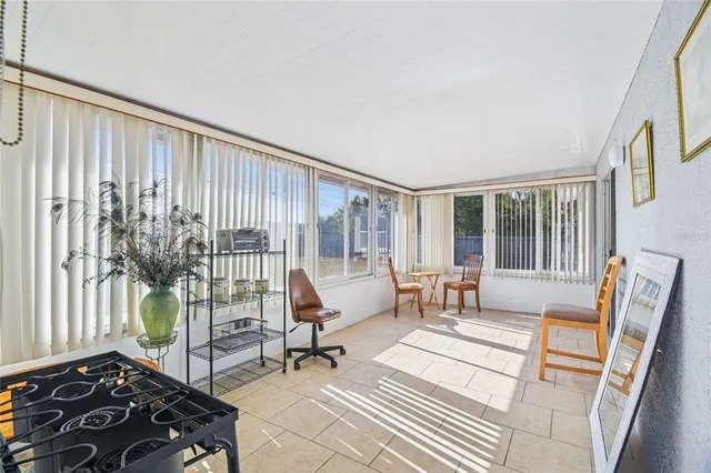 an aerial view of residential houses with yard and trees in the background