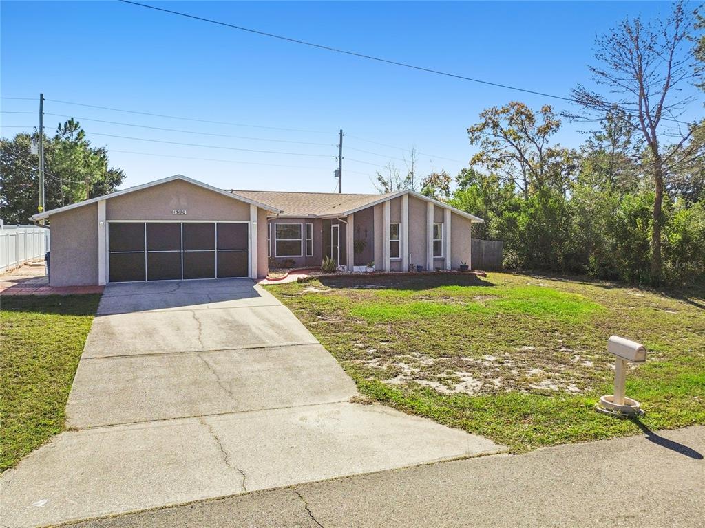 13170 Pirate Lane Spring Hill, FL 34609 - Photo 60 of 83 a view of a house with a yard and potted plants