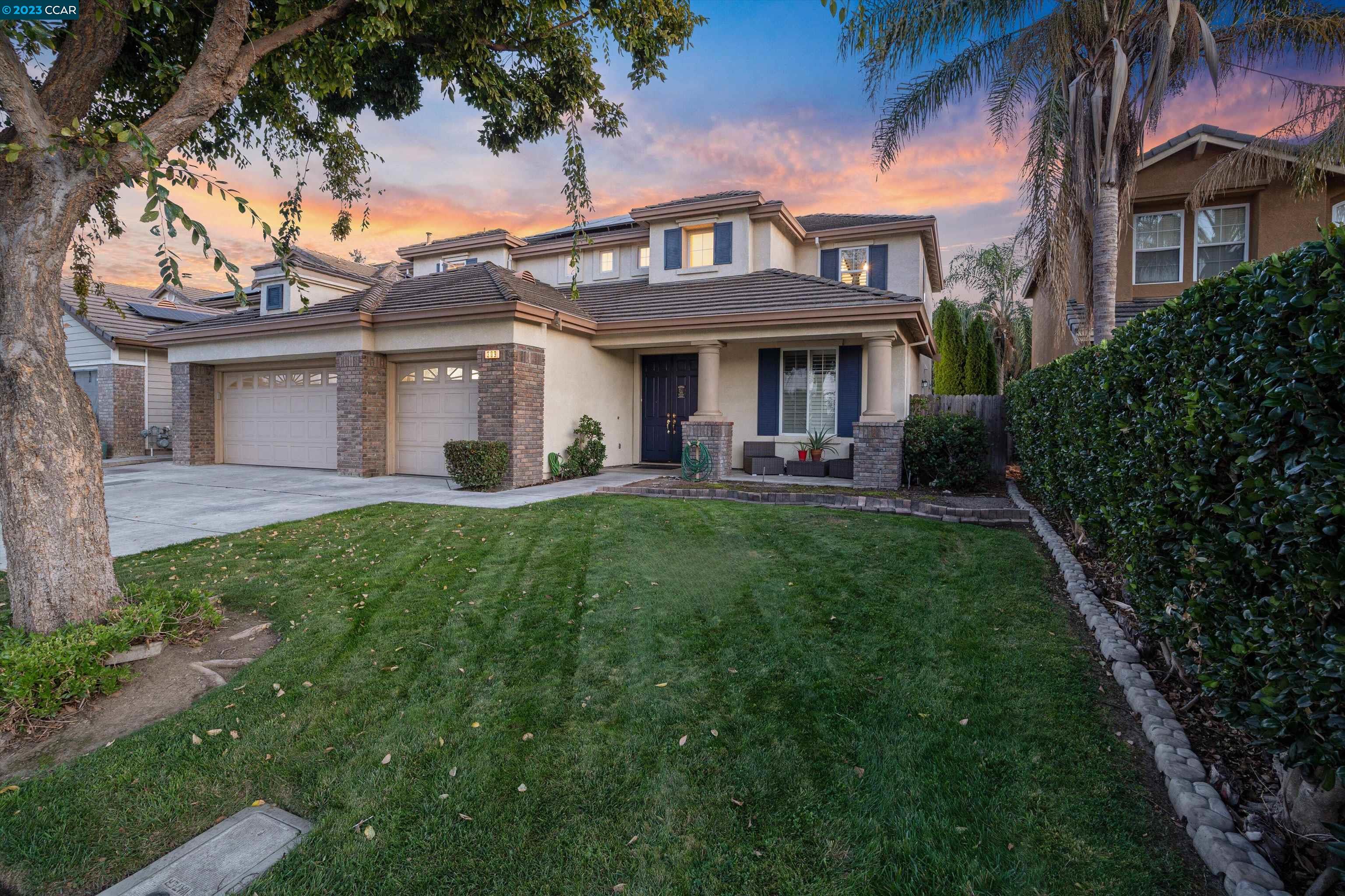 a front view of a house with a garden and plants