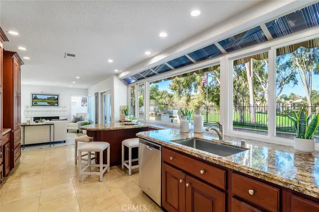 a kitchen with granite countertop a sink and dining table chair