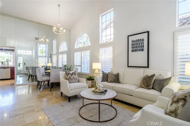 a living room with furniture a large window and a dining table