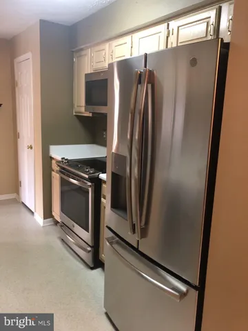 a kitchen with stainless steel appliances granite countertop a sink and a refrigerator