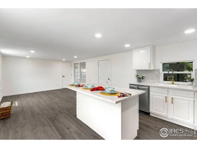 a kitchen with kitchen island a stove a counter top space and cabinets