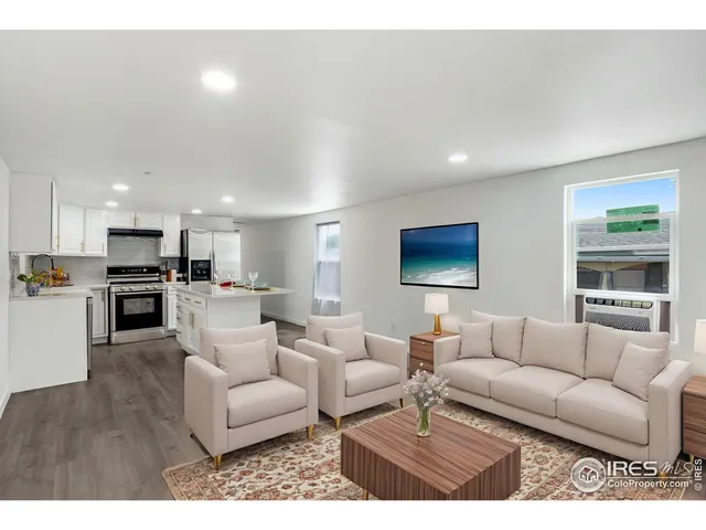 a living room with furniture and a view of kitchen
