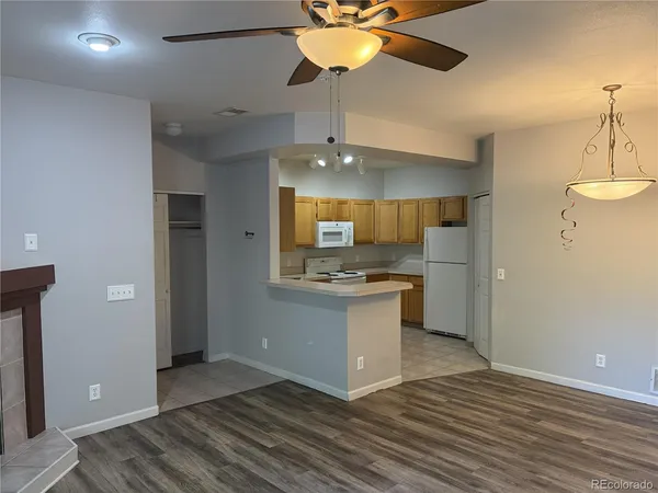 a view of kitchen with granite countertop cabinets and refrigerator