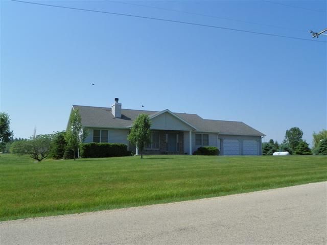 9967 East Center Road Stockton, IL 61085 - Photo 1 of 12 a view of a house with a big yard and large trees