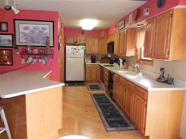 9967 East Center Road Stockton, IL 61085 - Photo 3 of 12 a kitchen with a refrigerator a sink and wooden cabinets