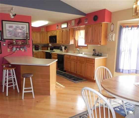 9967 East Center Road Stockton, IL 61085 - Photo 5 of 12 a kitchen with stainless steel appliances granite countertop a dining table chairs and a refrigerator