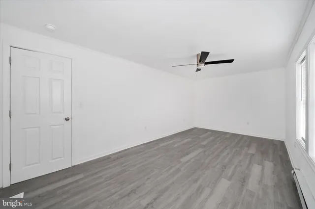 a view of a room with wooden floor and a ceiling fan