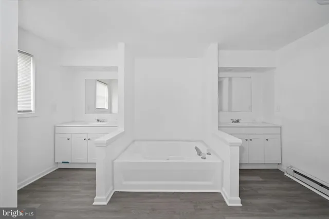 a spacious bathroom with bathtub shower and closet