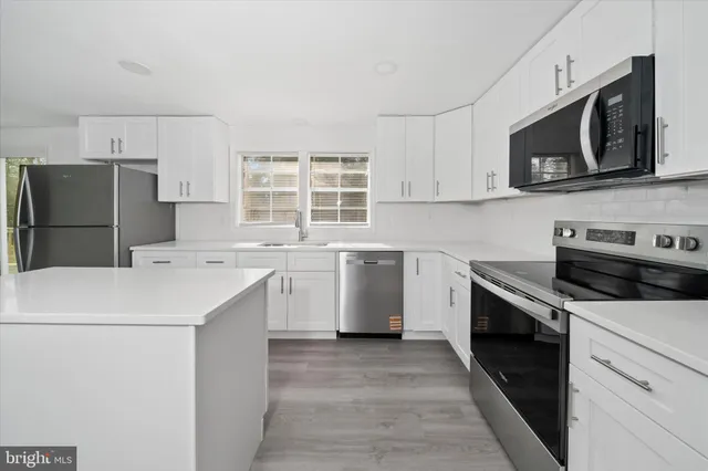 a kitchen with a sink stove and microwave