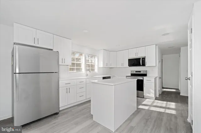 a kitchen with white cabinets and white appliances