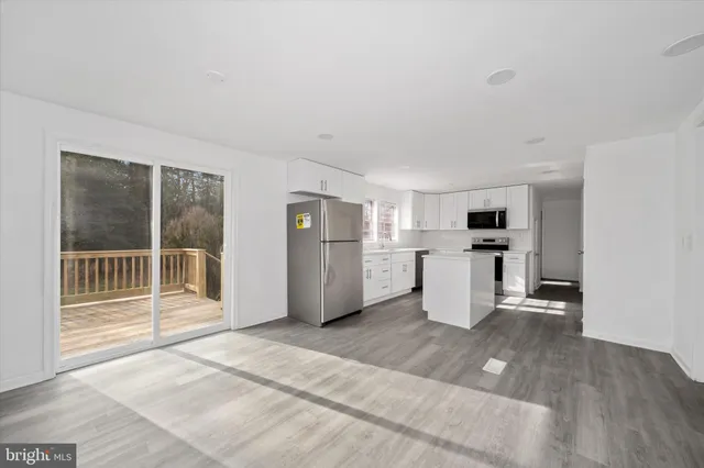 a view of a kitchen with a sink stove cabinets and a wooden floor