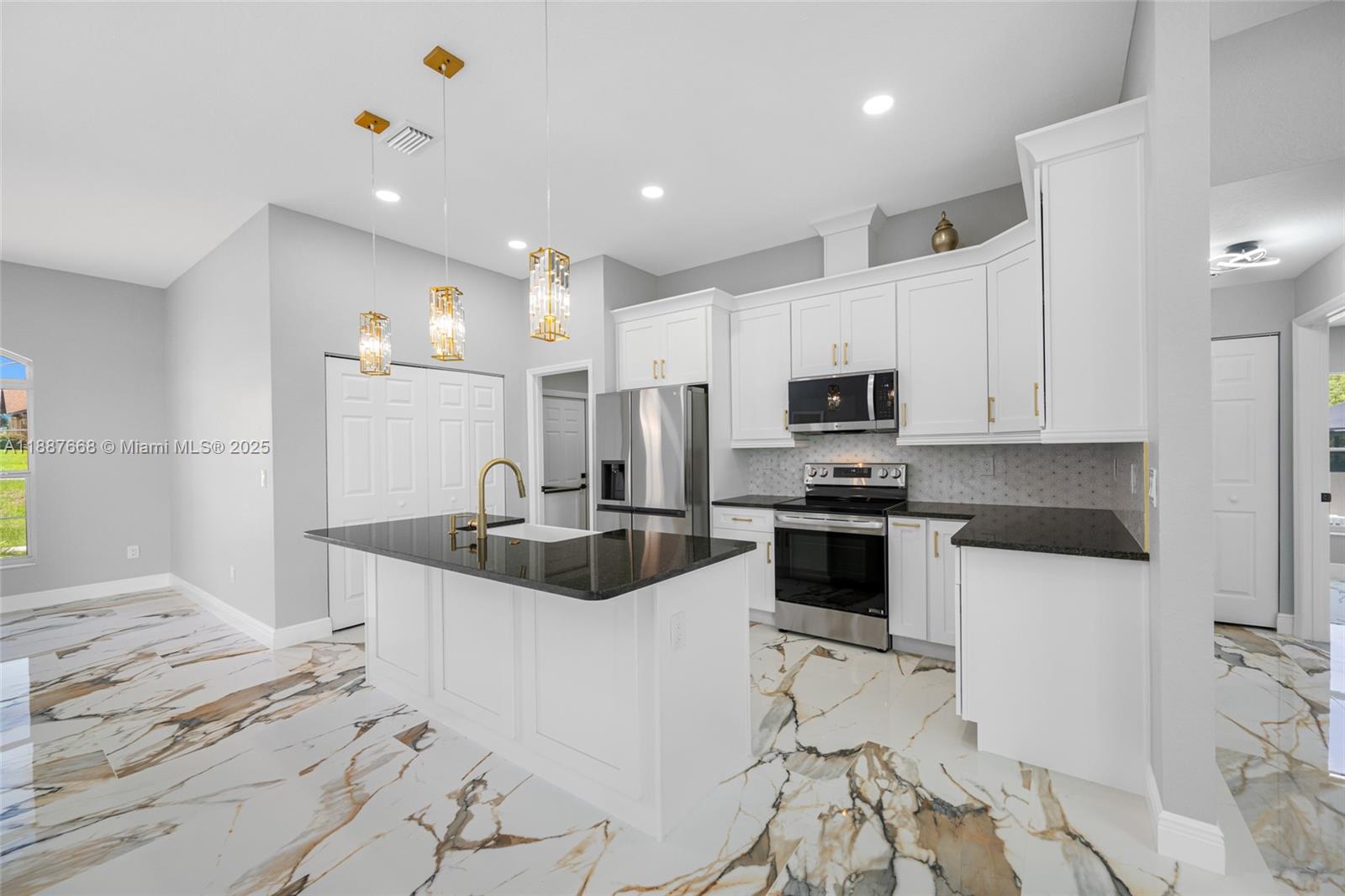 5317 Lydia Court Spring Hill, FL 34608 - Photo 6 of 10 a kitchen with stainless steel appliances granite countertop a sink and a refrigerator
