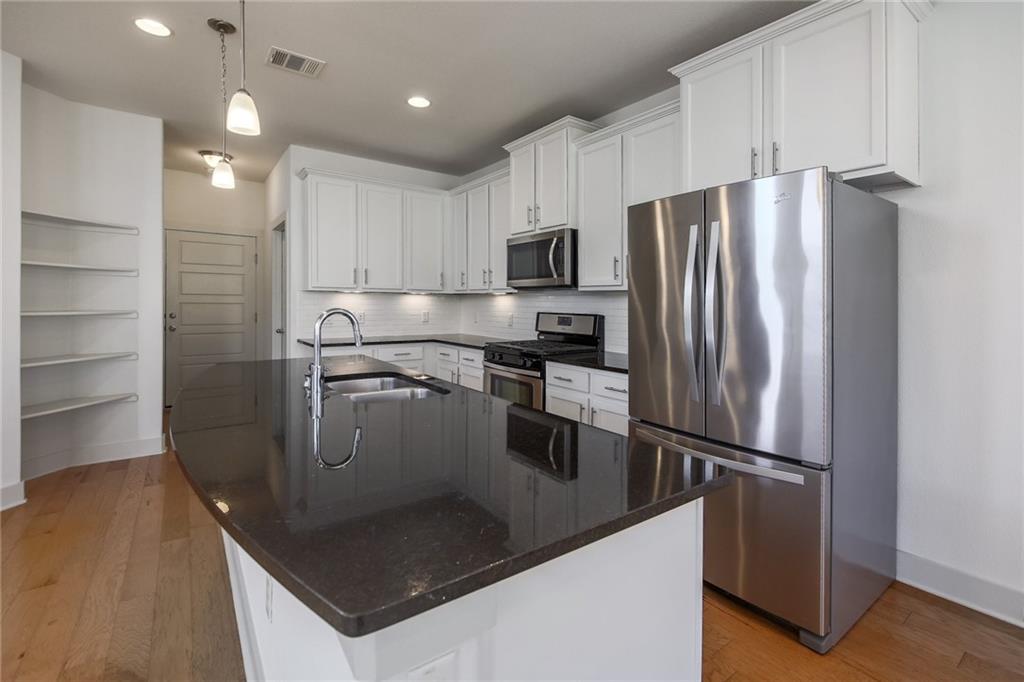 5809 Swayden Lane Austin, TX 78745 - Photo 5 of 10 Kitchen featuring granite countertops, island, and stainless appliances