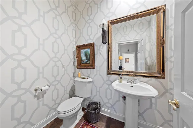 a bathroom with a toilet sink and mirror