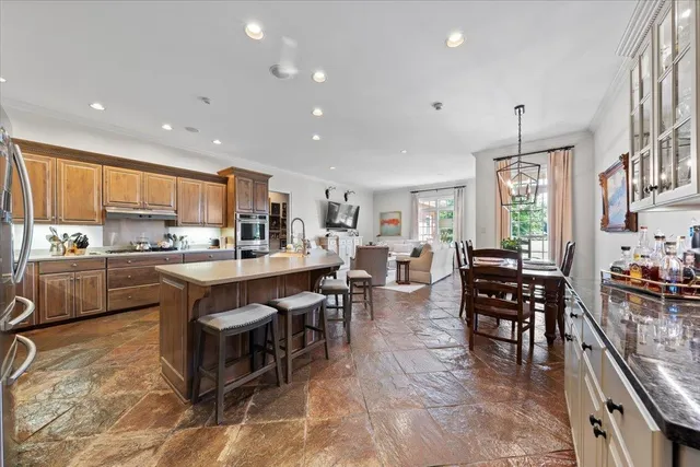 a large kitchen with kitchen island a dining table chairs and white cabinets