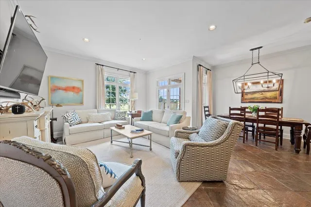a living room with furniture chandelier and a flat screen tv