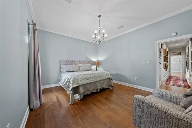 a spacious bedroom with a bed and a chandelier