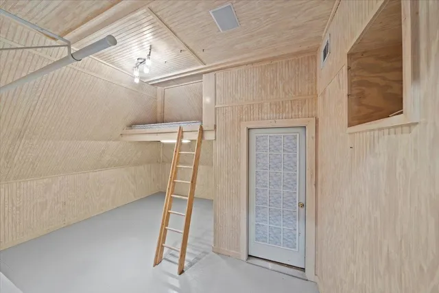 a view of a lobby with potted plants and a bench