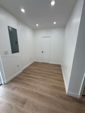an empty room with wooden floor and white walls