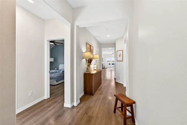 a view of a hallway with bathroom and wooden floor