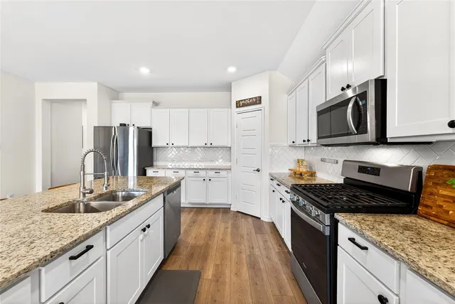 a kitchen with stainless steel appliances granite countertop a sink stove microwave and cabinets