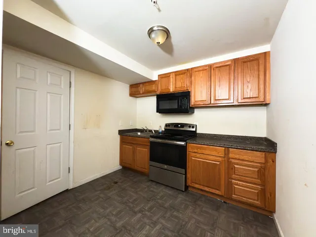a kitchen with stainless steel appliances granite countertop wooden cabinets a stove top oven and granite counter tops