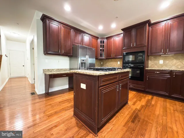 a large kitchen with stainless steel appliances granite countertop a stove a sink and a microwave