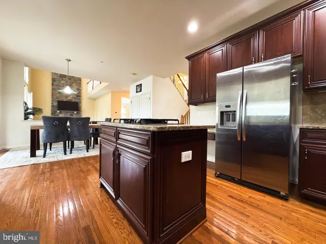 a large kitchen with stainless steel appliances granite countertop a stove a sink and a refrigerator