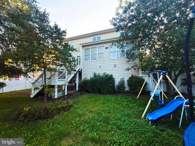 a view of a house with a yard deck and a slide