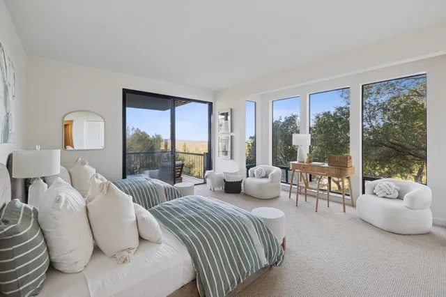 a bedroom with furniture and a large window