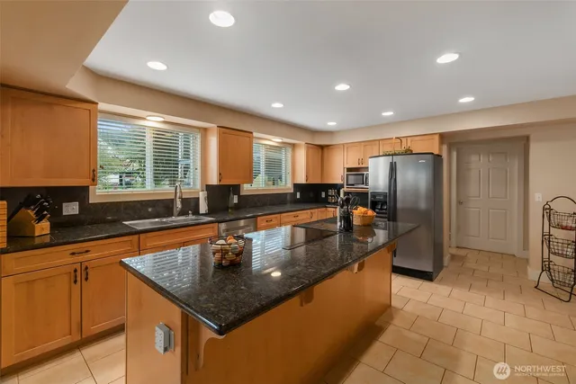 a kitchen with stainless steel appliances granite countertop a sink a stove and a refrigerator